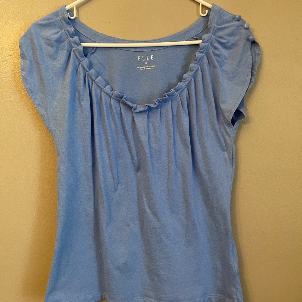 Elle light blue women’s top with cute buttons on the sleeve! Juniors size medium